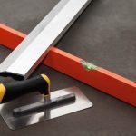 Construction stainless steel trowel tools on cement mortar floor