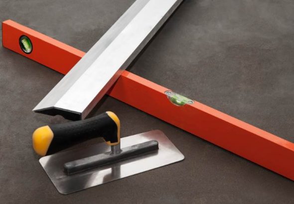 Construction stainless steel trowel tools on cement mortar floor