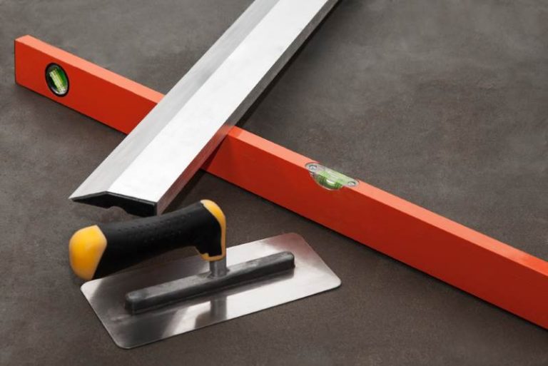 Construction stainless steel trowel tools on cement mortar floor